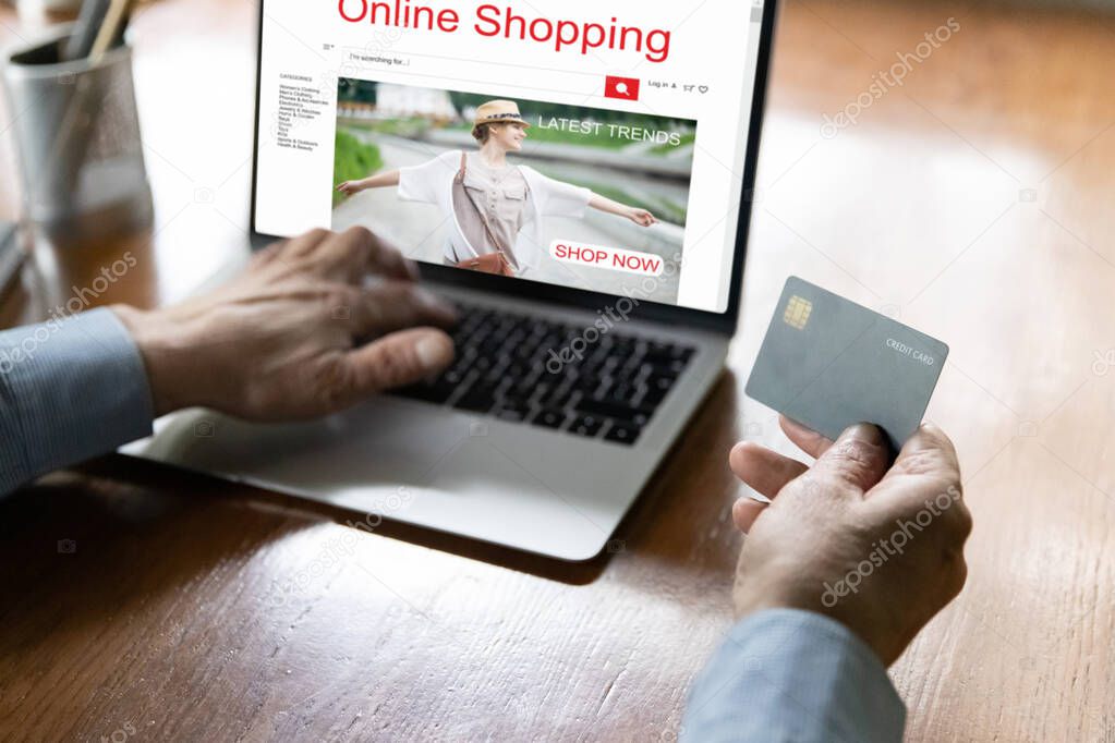 Close up mature man making secure internet payment, using laptop