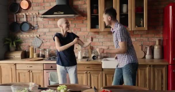 Cáncer femenino optimista paciente bailando en la cocina con el marido — Vídeos de Stock