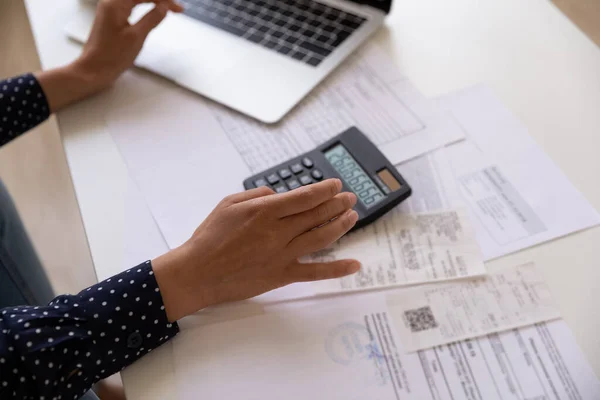 Mains de jeune femme prévoyant des frais financiers à l'aide d'une calculatrice d'ordinateur portable — Photo