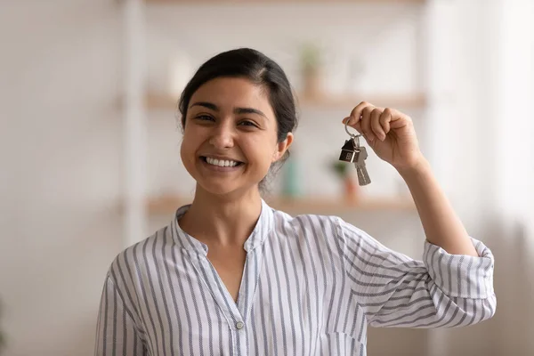 Mujer joven de raza mixta orgullosa dueño de casa mostrando llaves de piso —  Fotos de Stock