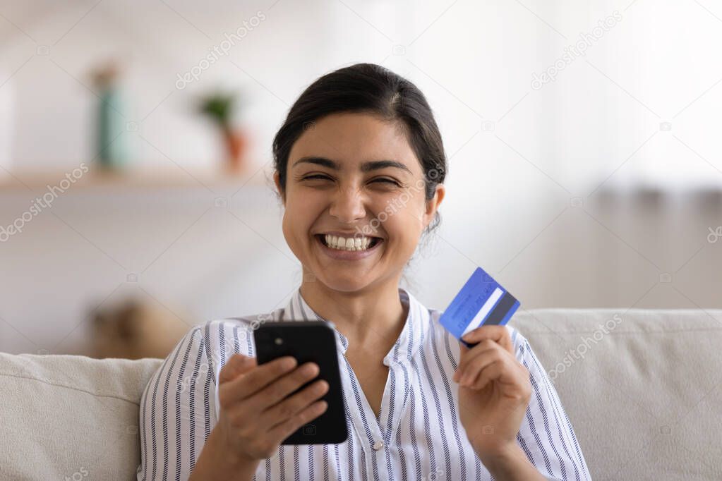Young indian lady having pleasure in spending money online