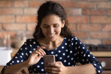 Gülümseyen genç kadın akıllı telefondan video görüşmesi yapıyor.