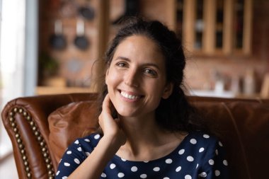 Gülümseyen beyaz kadın portresi kanepede rahatla.