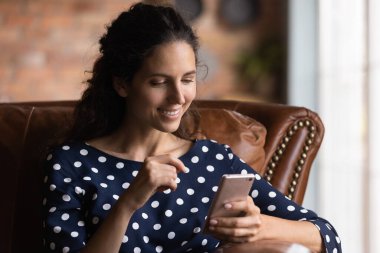 Gülümseyen kadın video konuşmasında akıllı telefon kullanıyor.