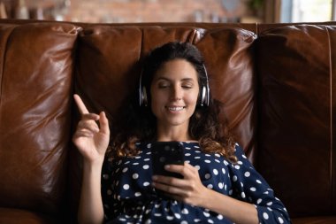 Mutlu kadın evde oturup müzik dinliyor.