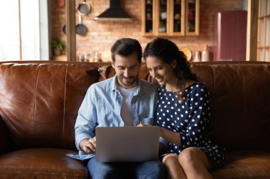 Mutlu çift evden bilgisayar alışverişi yapıyor.