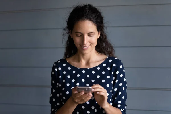 Smiling young woman use cellphone browsing internet — Stock Photo, Image