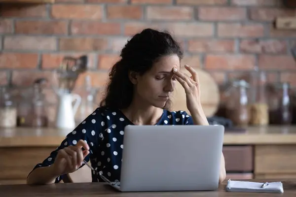 Moe vrouw werken op laptop lijden aan migraine — Stockfoto