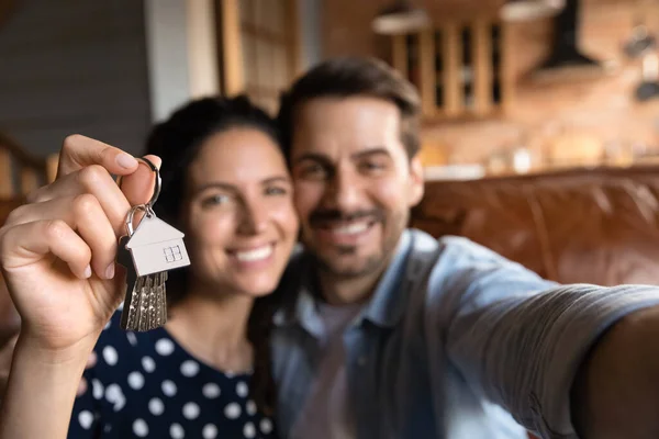 Primer plano de la pareja emocionada mostrar las claves para el hogar —  Fotos de Stock