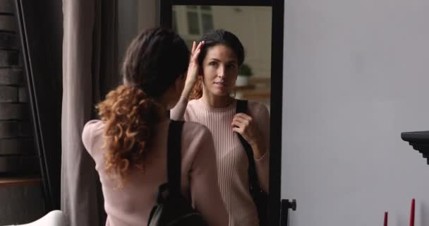 Smiling woman looking in mirror before going for a walk. — Stock Video