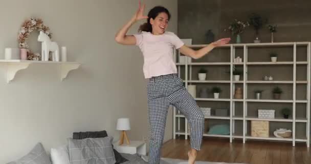 Gelukkig jong vrouw in pyjama dansen springen op slaapkamer. — Stockvideo