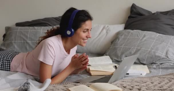 Glückliche junge Frau mit Kopfhörern kommuniziert distanziert mit Lehrerin. — Stockvideo