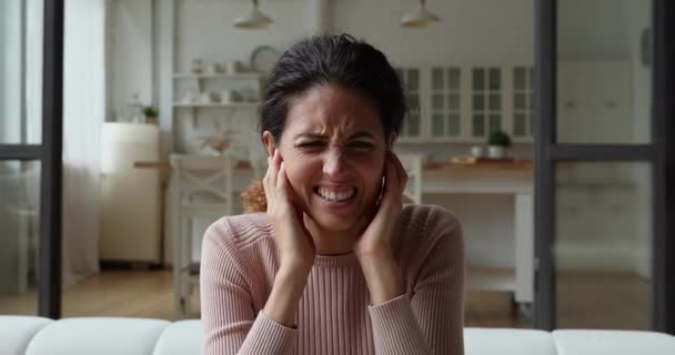 Mutsuz, stresli genç bir kadın parmaklarını kulaklarına tıkıyor.. — Stok video