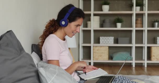 Enfocado joven mujer caucásica en los auriculares estudiando a distancia. — Vídeos de Stock