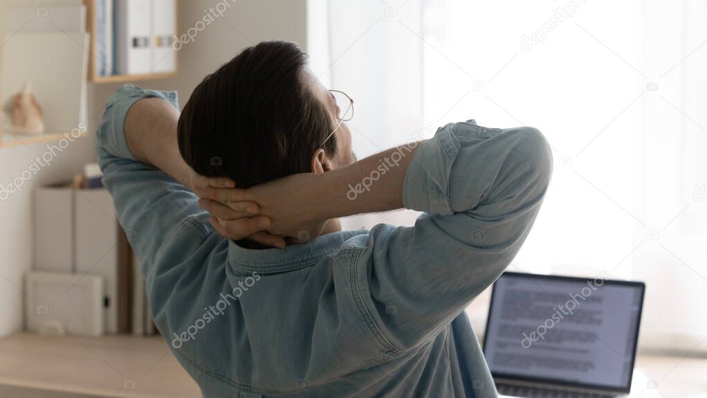 Young man freelancer taking short break of routine computer work