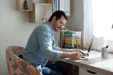 Genç adam internetten uzak öğrenim hakkında notlar alıyor.