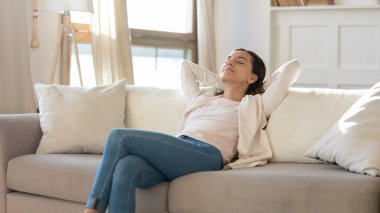 Huzurlu çekici kadın arkana yaslanıyor, rahat kanepeye uzanıyor.