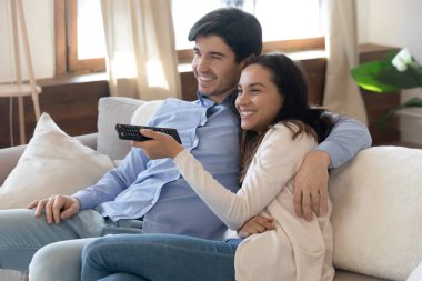Mutlu genç çiftin kucaklaşmasını, birlikte televizyon izlemesini.
