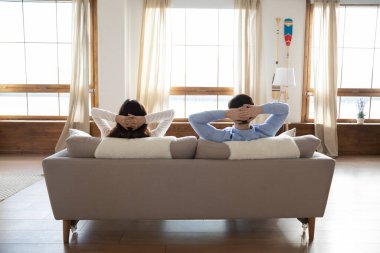 Modern apartmandaki kanepede dinlenen genç çift.