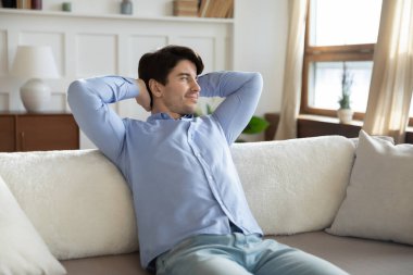 Tatmin olmuş genç bir adam bir tarafa bakıyor ve rahatlıyor.