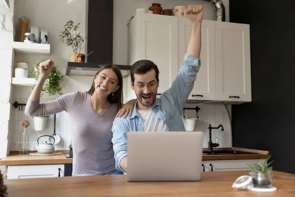 Jeune couple excité acclamant pour l'équipe de football en ligne à la cuisine — Photo