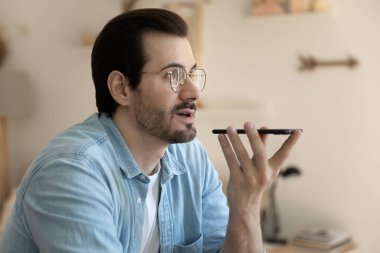 Kendinden emin genç bir adam arkadaşlarıyla yüksek sesle iletişim kuruyor.