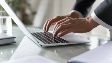 Ofiste dizüstü bilgisayar kullanarak, klavyede yazı yazarak işadamını kapat