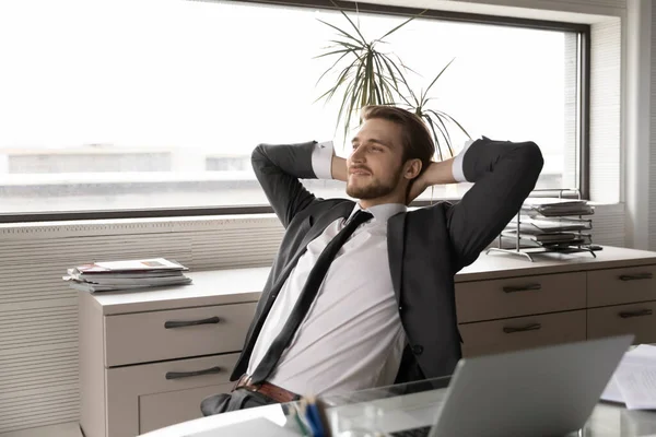 Hombre de negocios satisfecho estirándose en la silla de la oficina después del trabajo hecho —  Fotos de Stock