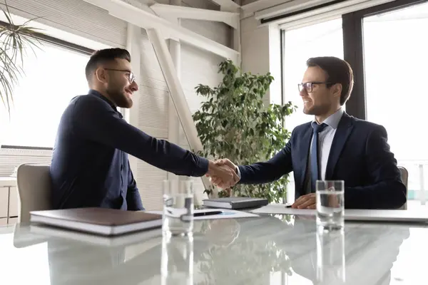 Vista laterale felice diversi partner commerciali stringendo la mano, facendo affare — Foto Stock