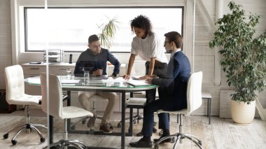 Kurul odasında çalışanlarla çalışan kendinden emin Afrikalı Amerikalı takım lideri.