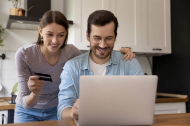 E-bankacılık uygulaması ile online ödeme yapan mutlu genç eşler