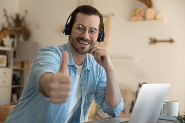 Kameraya bakan genç öğrenci, baş parmağını kaldırıp e-öğrenim öneriyor.