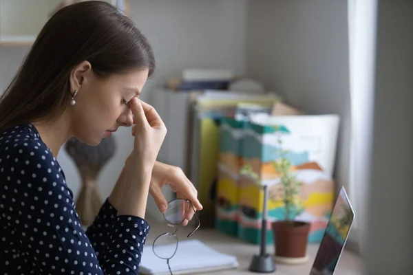 Jong vrouw overwerkt door computer het nemen van bril af wrijven neus — Stockfoto