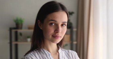 Mutlu, çekici, 25 'li yaşlarda bir kadın kameraya bakıyor..