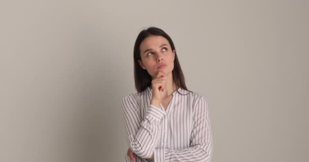 Pensive puzzled young businesswoman looking in distance. — Stock Video