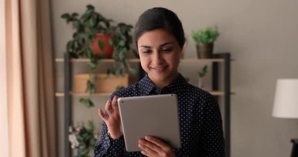 Счастливая молодая индийская этническая женщина, использующая цифровые планшеты. — стоковое видео