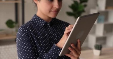 Dokunmatik ped kullanan gülümseyen Hintli etnik kadın.