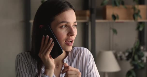 Mulher jovem olhando à distância, falando por telefone celular. — Vídeo de Stock