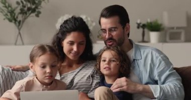 Ebeveynler ve küçük çocukları dizüstü bilgisayar kullanarak zaman geçiriyorlar.