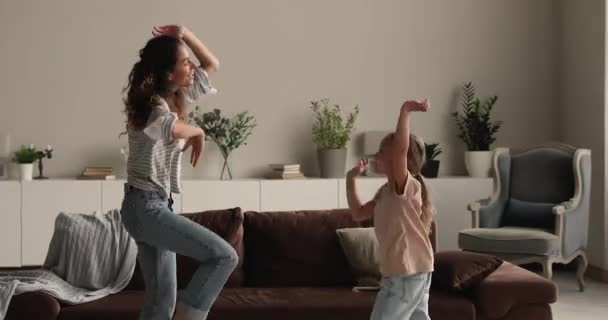 Mor og datter danser sjovt bevæger sig sammen i stuen – Stock-video