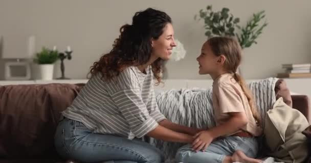 Mamma och lilla dottern njuter av kommunikation sitter tillsammans på soffan — Stockvideo