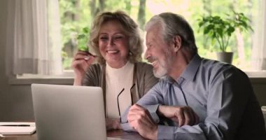 Mutlu orta yaşlı evli çift internette komik bir film izliyor..