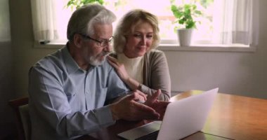 Mutlu, olgun bir çift evde sörf yapıyor..