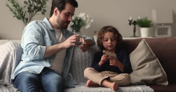 Apa játszani fiával kezében játék fegyverek lőni otthon — Stock videók