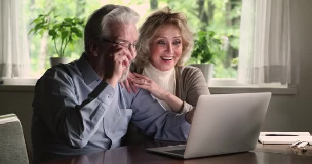 Verheugd glimlachend bejaarde echtpaar krijgen e-mail met ongelooflijk nieuws. — Stockvideo