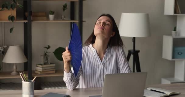 Unhappy young woman feeling overheated in modern office. — Stock Video