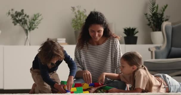 Los niños pequeños juegan con la madre sentada en el suelo caliente — Vídeos de Stock