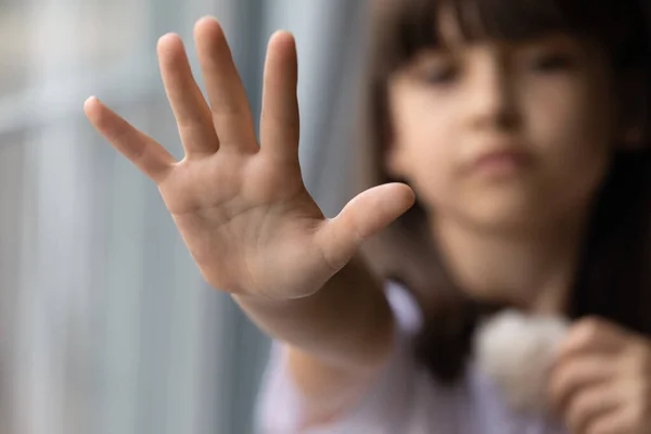 Закрыть одинокую маленькую девочку, предлагающую руку, прося помощи — стоковое фото