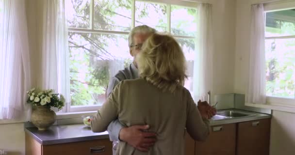 Романтична сімейна пара середнього віку обертається на кухні . — стокове відео