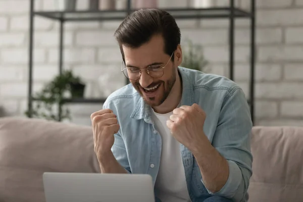 Close-up dolblij man het dragen van een bril vieren succes, met behulp van laptop — Stockfoto